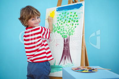 Happy boy painting his picture