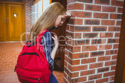 Worried student leaning against the wall