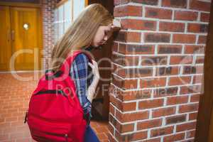 Worried student leaning against the wall