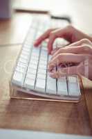 Cropped image of woman typing on keyboard