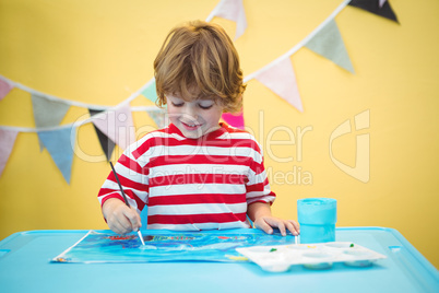 Smiling boy painting a picture