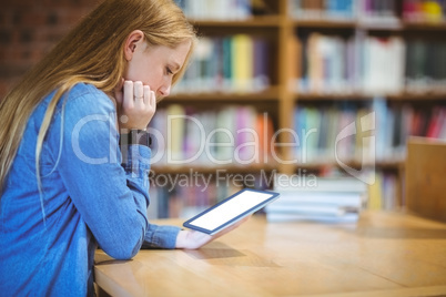 Student with smartwatch using tablet in library