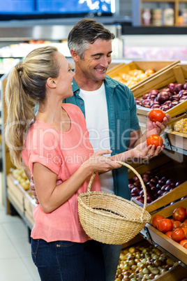 Happy couple holding tomatoes