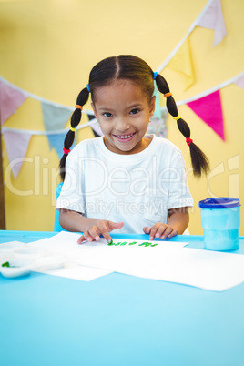 Smiling girl painting with her fingers