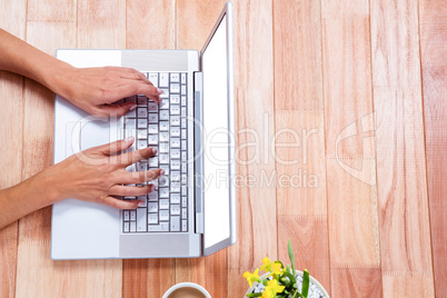 Overhead of feminine hands using laptop