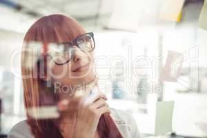 Attractive hipster woman looking at sticky notes