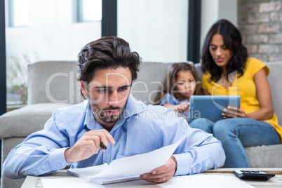 Thoughtful father paying bills in living room