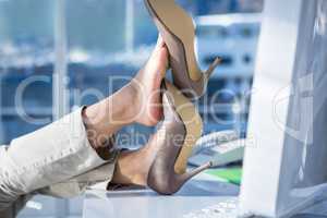 Businesswoman with her legs on her desk