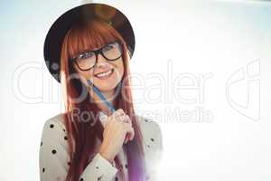 Smiling hipster woman posing with a pencil