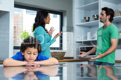 Sad child listening to parents argument