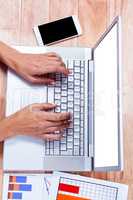 Overhead of businesswoman hands using laptop