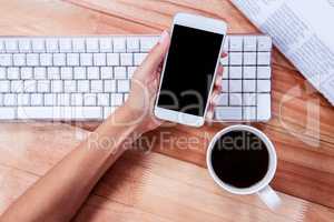 Businesswoman holding hot beverage and smartphone