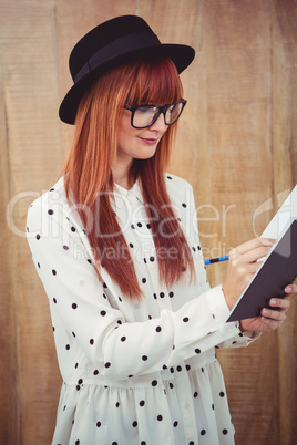 Attractive hipster woman writing on notepad