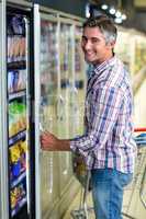 Man opening supermarket fridge