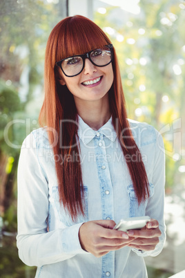 Smiling hipster woman using smartphone