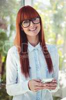 Smiling hipster woman using smartphone