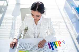 Businesswoman using her pc with documents