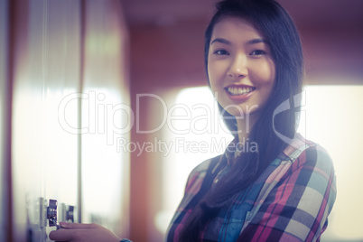 Smiling student opening locker