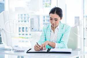 Smiling businesswoman with notes at desk