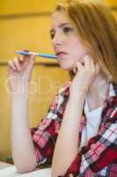Unsure student holding pen during class