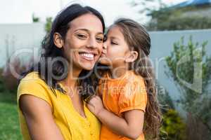 Cute daughter kissing her mothers cheek