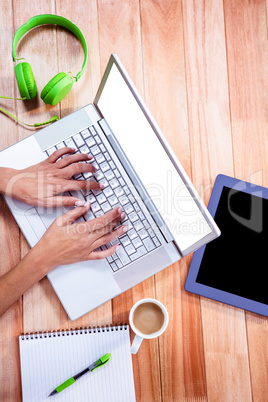 Overhead of feminine hands typing on laptop