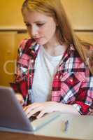 Focused student using laptop during class