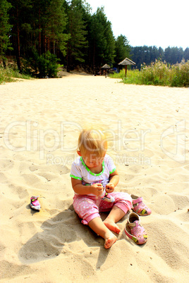 baby plays on the river sand