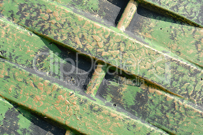 Green metal texture with patches of rust steel on its surface, taken outdoor