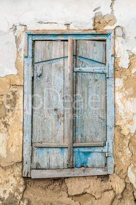 Old wooden window shutters on the background of the destroyed wa