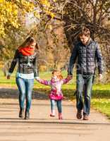 Happy young family walks in the park