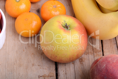 Mandarin Apples Bananas Peach on wooden plate