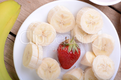 healthy strawberry and bananas slices on wooden background