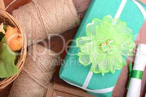 green christmas gift box, white paper with bow on wooden table.