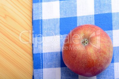 Red apple top view on blue material background