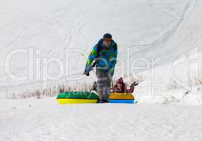 Father and daughter with snow tube