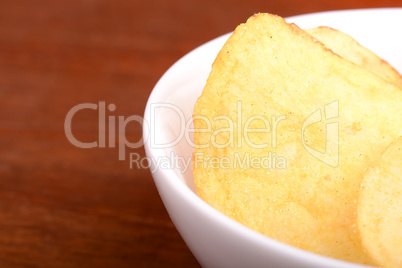 Crispy potato chips close up on white plate