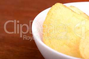 Crispy potato chips close up on white plate