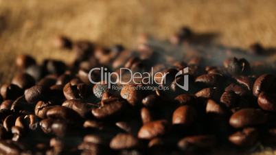 Selected aromatic coffee beans on sackcloth with smoke