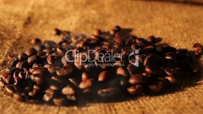 Selected aromatic coffee beans on sackcloth with smoke