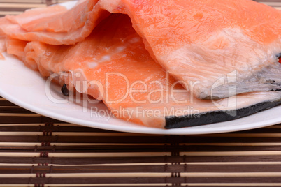 Raw salmon fish steaks with fresh herbs on white plate