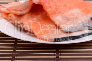 Raw salmon fish steaks with fresh herbs on white plate
