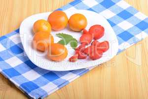 A slice of red strawberry on white plate with mandarin and strawberry slices