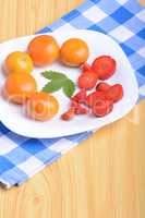 A slice of red strawberry on white plate with mandarin and strawberry slices