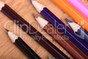 Frame of old Colour pencils on Old wooden plate texture background