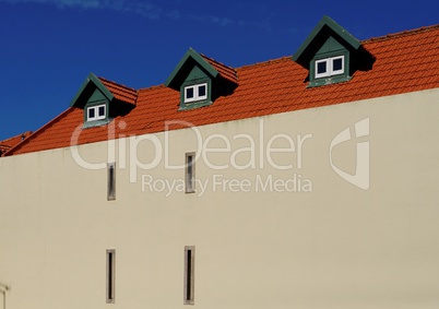 A house with red tile roof and three garrets