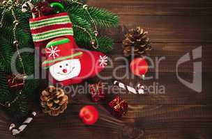 Christmas sock with toys and gifts on wooden background with Christmas tree