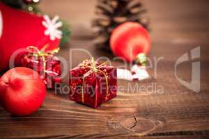 Christmas gift box with red ribbon on dark wooden background in vintage style
