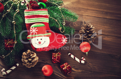 Christmas sock with toys and gifts on wooden background with Christmas tree