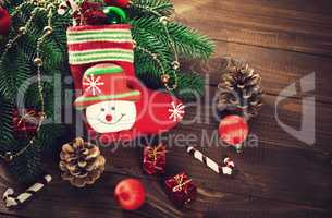 Christmas sock with toys and gifts on wooden background with Christmas tree